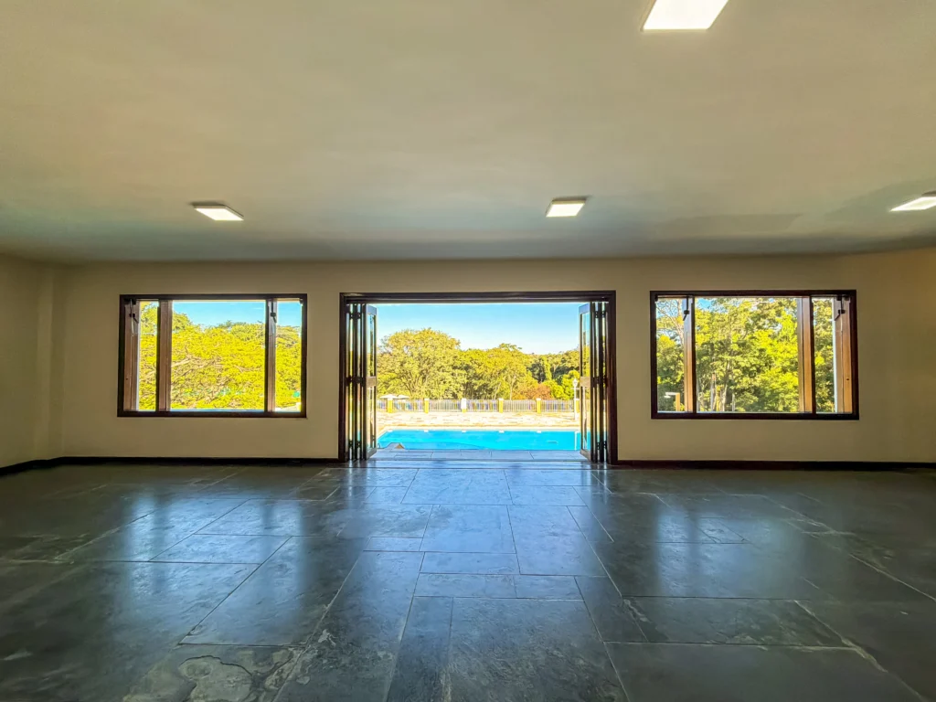 Salão de eventos com portas de vidro abertas para a piscina